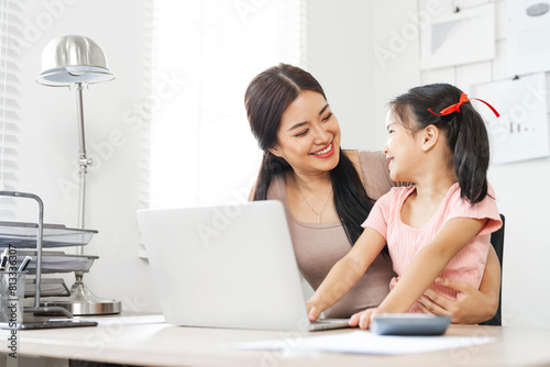 Family concept. Beautiful Mom is  taking care of her daughter while working from home.