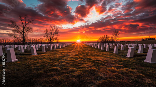 A dramatic sunset over a tranquil battlefield cemetery, where rows of white gravestones stand in silent tribute to fallen soldiers who gave their lives in service to their country,