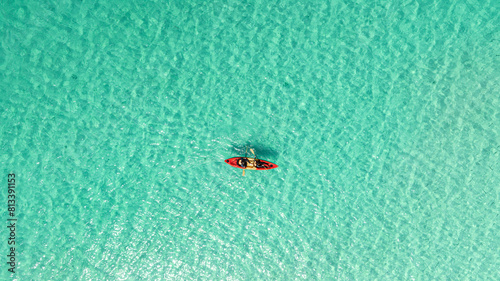 Aerial view of a woman and a young man kayaking on clear blue waters at Andaman Island. She does water sports activities. © Photo Sesaon