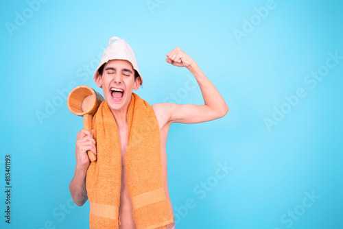 Healthy lifestyle. Retro style. A young attractive man is steaming in a Finnish sauna. Blue background.