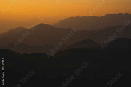 nature traveling with orange sky and layer of mountain with sunrise background © tickcharoen04