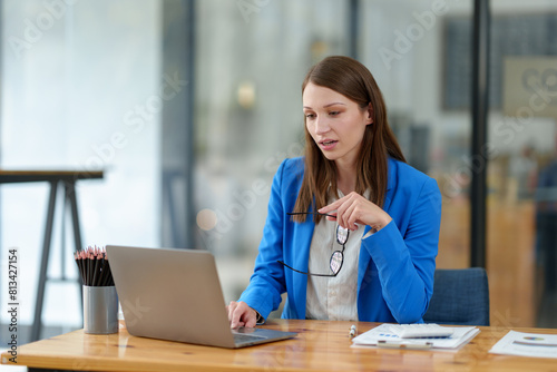 African businesswoman sitting and working on laptop at office African businesswoman American holding glasses, smiling, happy at work concept of success online business.