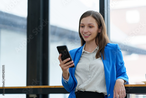 African businesswoman American uses smartphone while working on laptop at office Businesswoman working on the phone online applications Success concept, relaxation, online ordering.