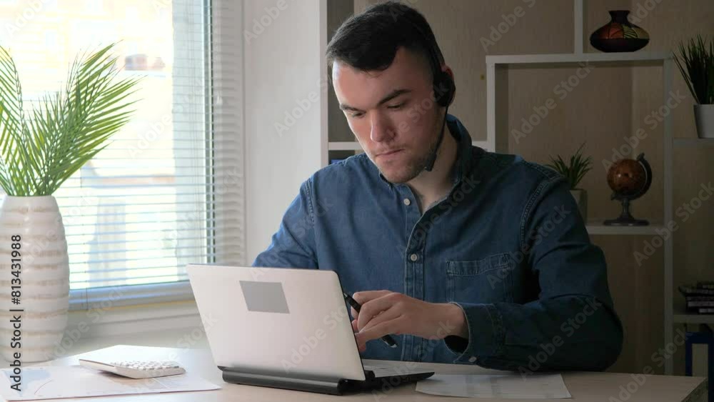 A young manager works on a computer and a calculator in the office, drawing up a business project. He works with business papers, carefully studying and analyzing them. Slow motion. A young manager works on a computer and a calculator in the office, drawing up a business project. He works with business papers, carefully studying and analyzing them. Slow motion.
