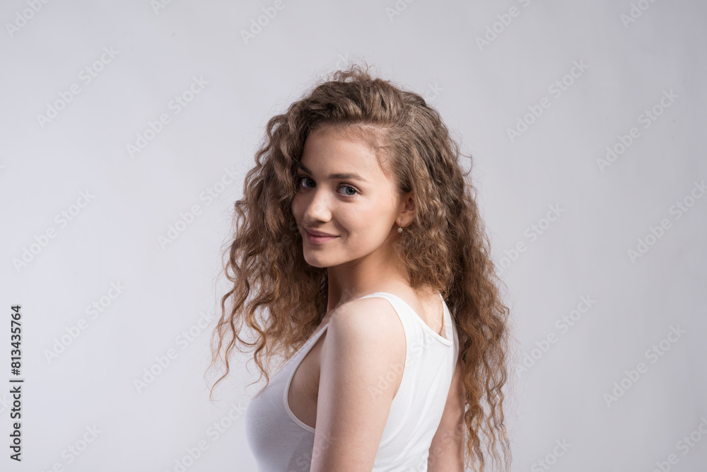 Portrait of a gorgeous teenage girl with curly hair. Studio shot, white background with copy space Portrait of a gorgeous teenage girl with curly hair. Studio shot, white background with copy space
