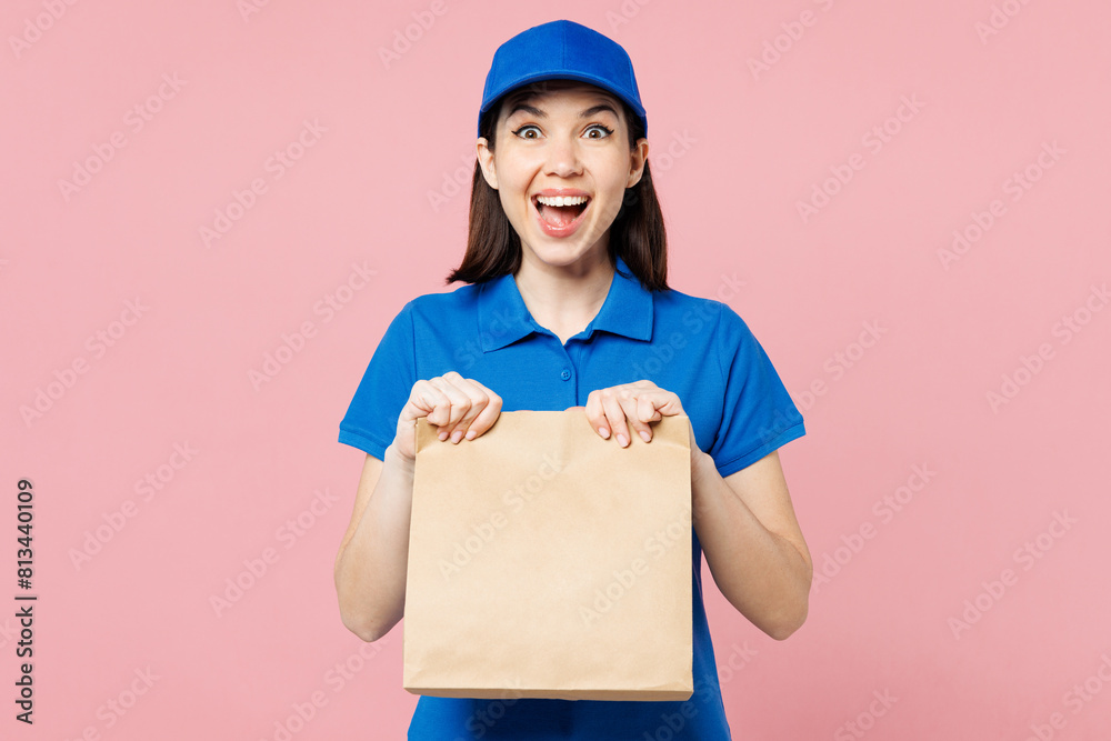 Professional amazed delivery girl employee woman wear blue cap t-shirt uniform workwear work as dealer courier hold brown clear blank craft paper bag isolated on plain pink background Service concept Professional amazed delivery girl employee woman wear blue cap t-shirt uniform workwear work as dealer courier hold brown clear blank craft paper bag isolated on plain pink background Service concept