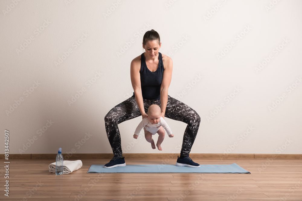 Home exercise for mother and baby, mommy and me workout. Using the baby's weight to perform squats Home exercise for mother and baby, mommy and me workout. Using the baby's weight to perform squats
