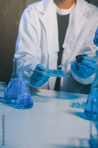 chemist,scientist hand dropping chemical liquid into test tube, science research and development concept