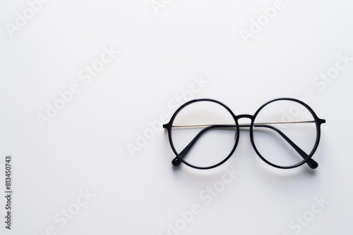 Minimalistic composition of round black eyeglasses on white background