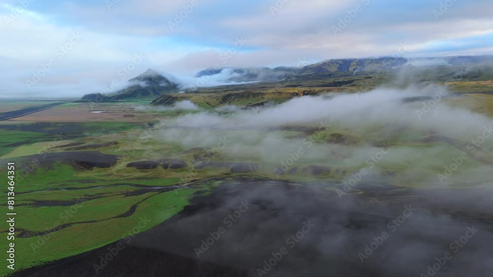 A captivating aerial view shows clouds floating over the verdant fields and distant mountains of Iceland, showcasing the tranquil and ethereal essence of the Icelandic highlands. Iceland. A captivating aerial view shows clouds floating over the verdant fields and distant mountains of Iceland, showcasing the tranquil and ethereal essence of the Icelandic highlands. Iceland.
