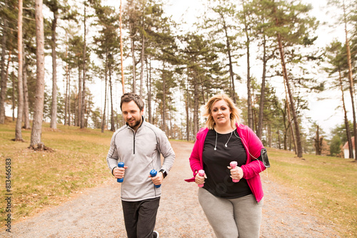 Obraz na plátně An overweight woman running in nature with friend