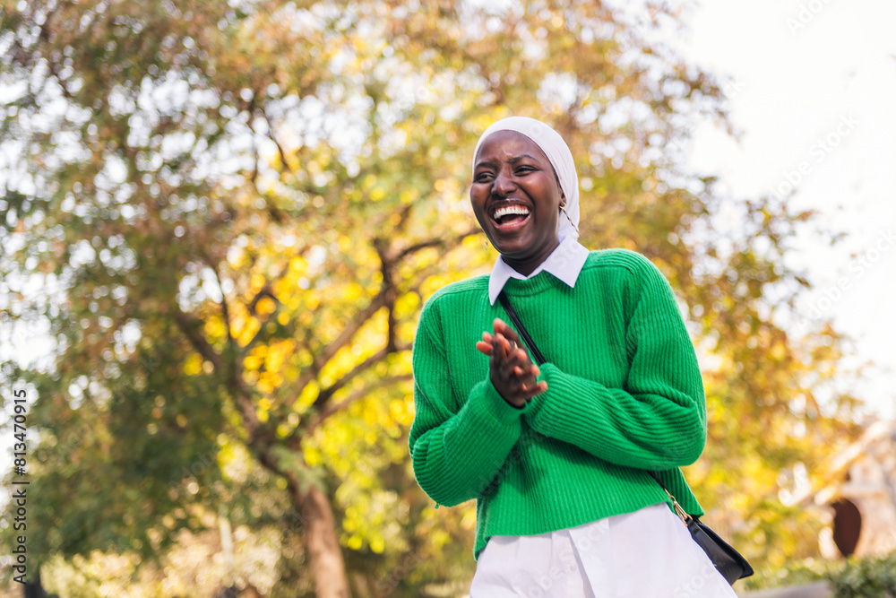 Obraz premium happy muslim black woman laughing funny, concept of tradition and modern lifestyle, copy space for text