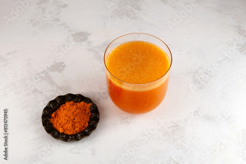 Buckthorn and mango fruits energy drink with natural turmeric powder on the table, top view. Healthy smoothie for immune support. Antioxidant drink photo