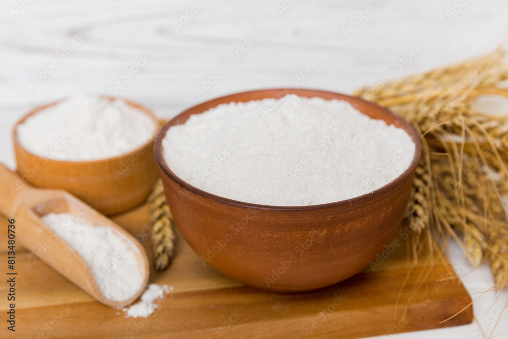 Flat lay of Wheat flour in wooden bowl with wheat spikelets on colored background. world wheat crisis