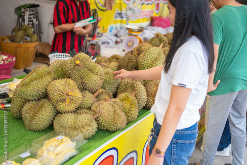 Asian woman buy a durian in street market. photo
