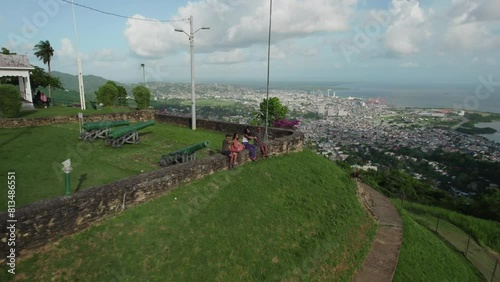Drone view of friends sittting on a wall at Fort King George, Port of Spain Trinidad photo