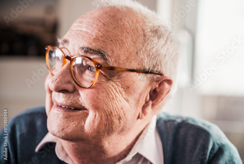Thoughtful retired senior man wearing eyeglasses at home photo