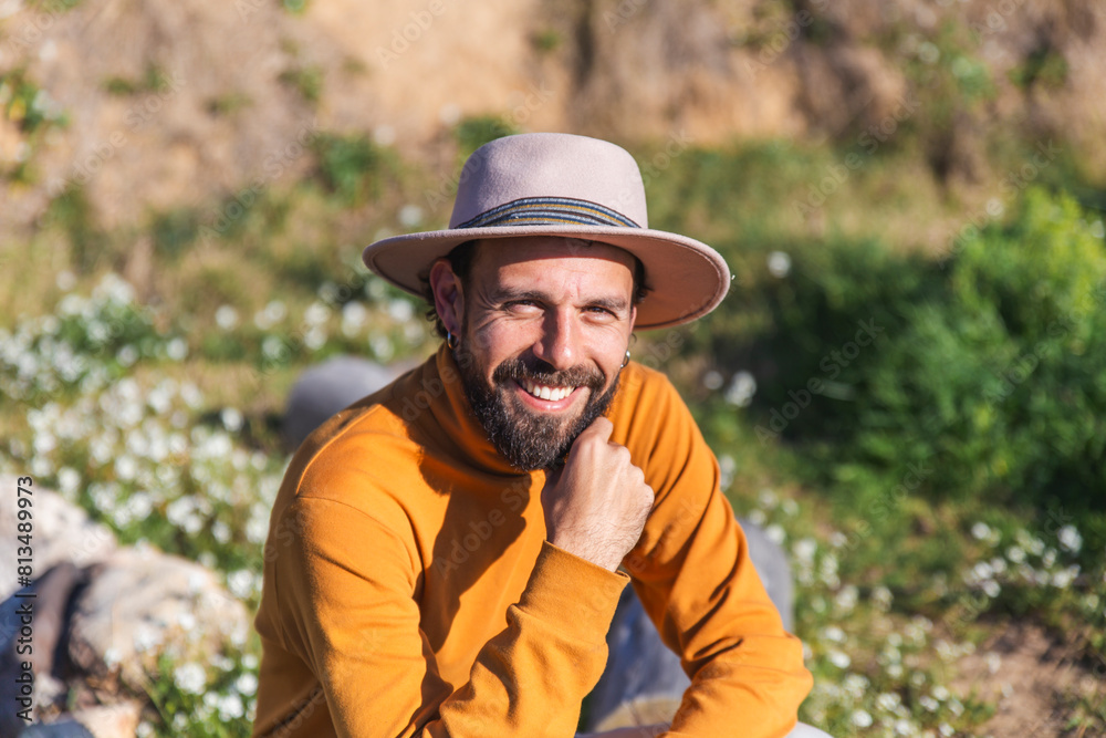 Smiling man wearing hat and sitting on sunny day Smiling man wearing hat and sitting on sunny day