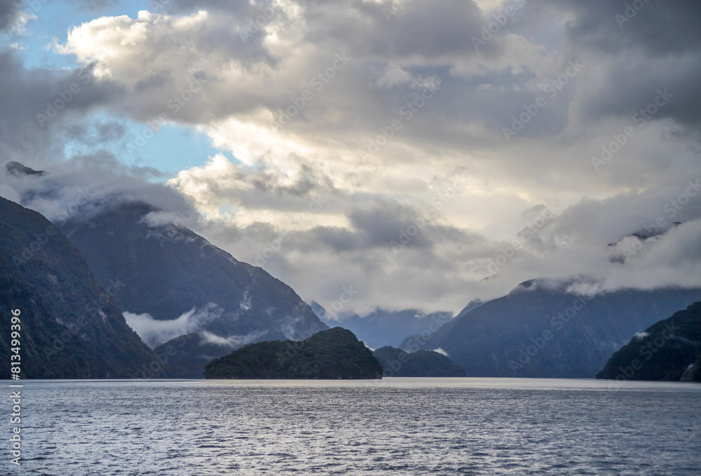 Seascape, dawn and early morning over the water in a fjord in cloudy weather, Doubtful Sound Fiord, New Zealand Seascape, dawn and early morning over the water in a fjord in cloudy weather, Doubtful Sound Fiord, New Zealand