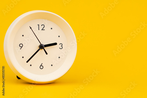 Clock on a yellow background, working with time and planning life, studio photo