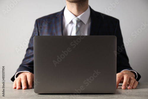 A man in a suit works on a laptop