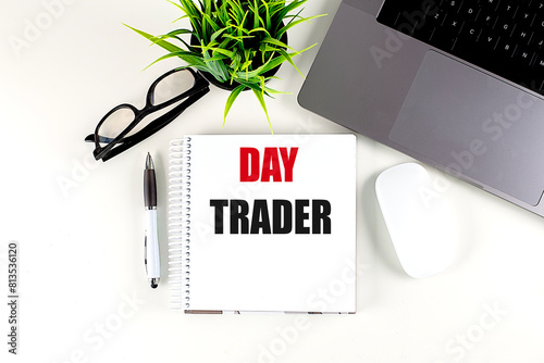 Photos DAY TRADER text on notebook with laptop, mouse and pen