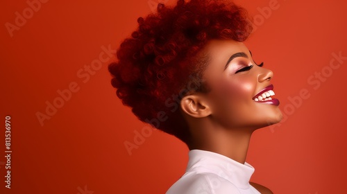 Beautiful, sexy, happy smiling dark-skinned African American woman with perfect skin and red hair, on a red background, banner.