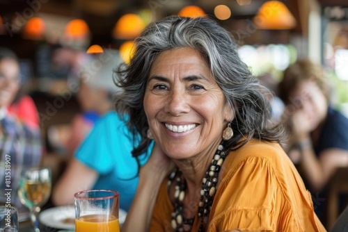 Portrait of smiling mature woman sitting at dining table in restaurant