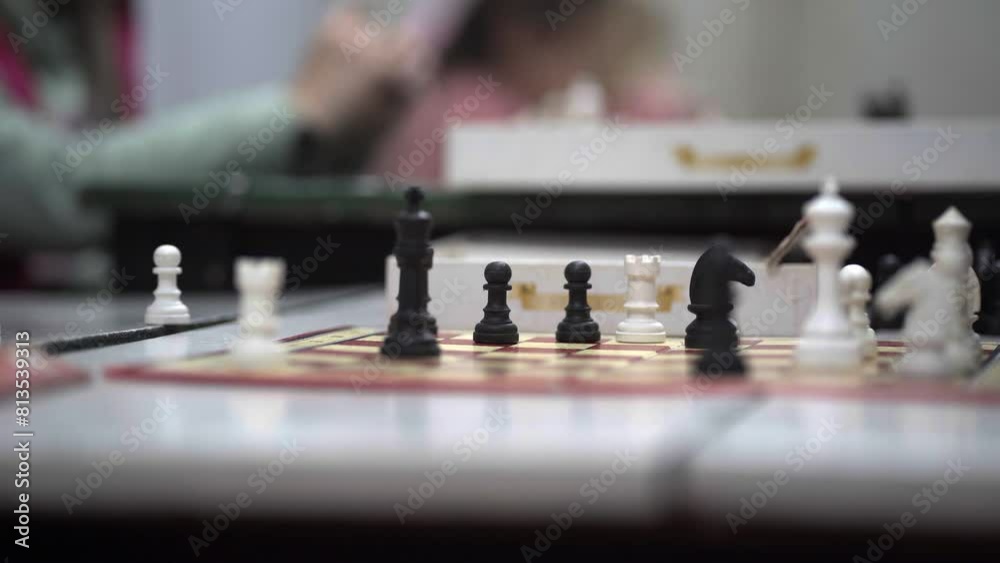 Close-up of a chessboard where two boys play during a chess lesson. Close-up of a chessboard where two boys play during a chess lesson.