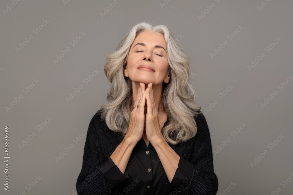 A woman with her eyes closed and hands raised. Suitable for meditation or relaxation concepts A woman with her eyes closed and hands raised. Suitable for meditation or relaxation concepts