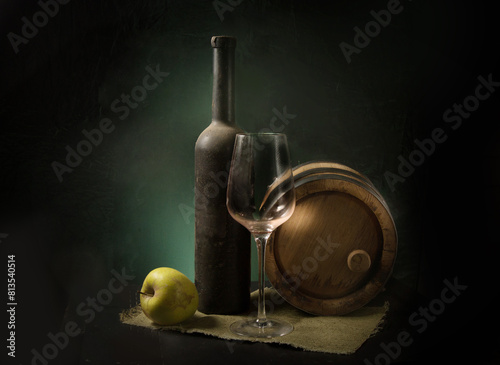 a bottle of wine, a glass, a wooden barrel and an apple on the table