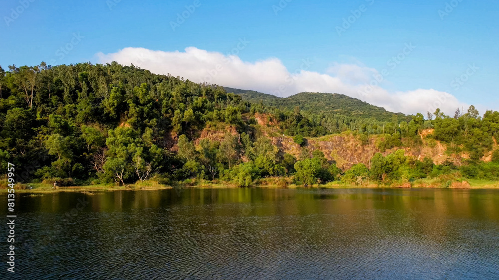 Aerial view of a serene lake by a forest near the coastline, ideal for themes of nature conservation, Earth Day, and outdoor recreation