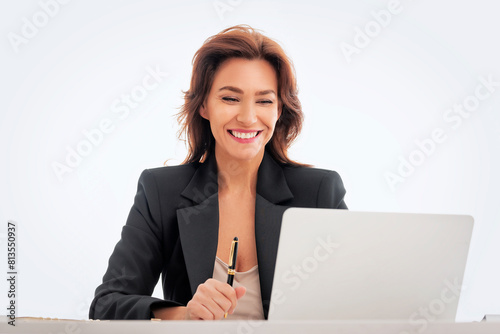 Businesswoman sitting at desk and using laptop against isolated background