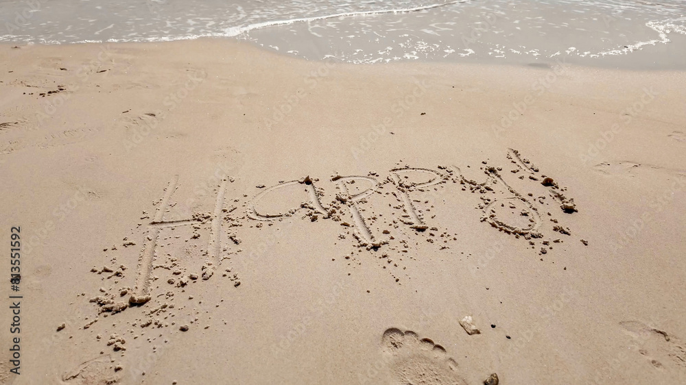 Handwritten 'Happy' message on a sandy beach with approaching waves, ideal for themes of joy, summer vacations, and beach holidays Handwritten 'Happy' message on a sandy beach with approaching waves, ideal for themes of joy, summer vacations, and beach holidays