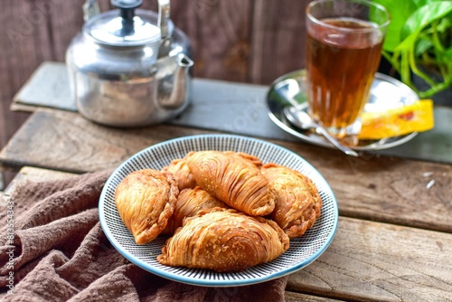 curry puff , karipap with hot tea and teapot  wooden blackground retro style photo