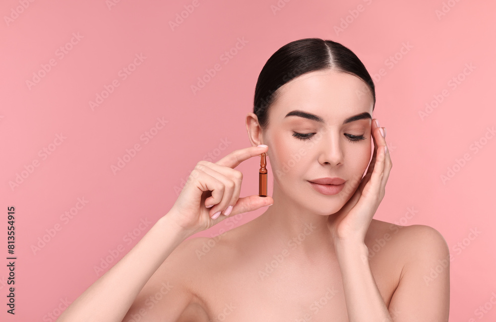 © New Africa - Beautiful young woman holding skincare ampoule on pink background © New Africa - Beautiful young woman holding skincare ampoule on pink background