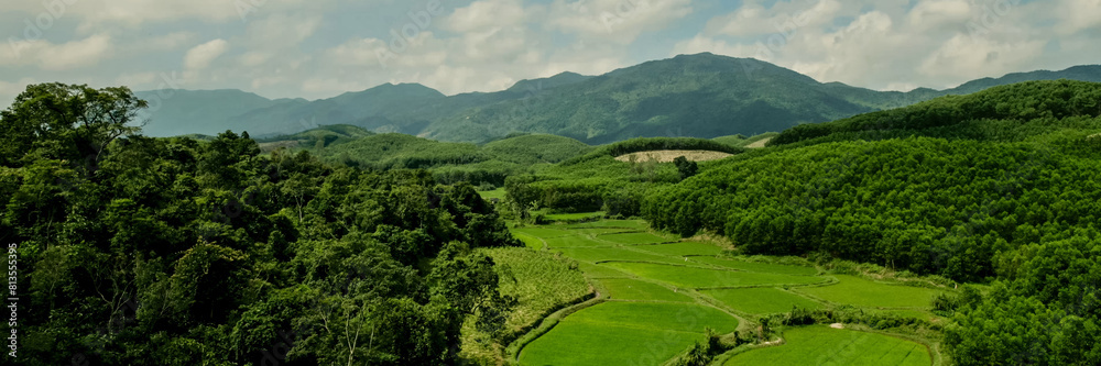 Panoramic view of lush green valleys and forested mountains under a clear sky, ideal for Earth Day promotions and nature-inspired design projects