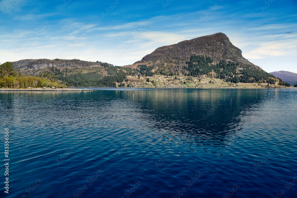 Fototapeta premium Island with rocks and trees in the fjord in front of the open sea in Norway.