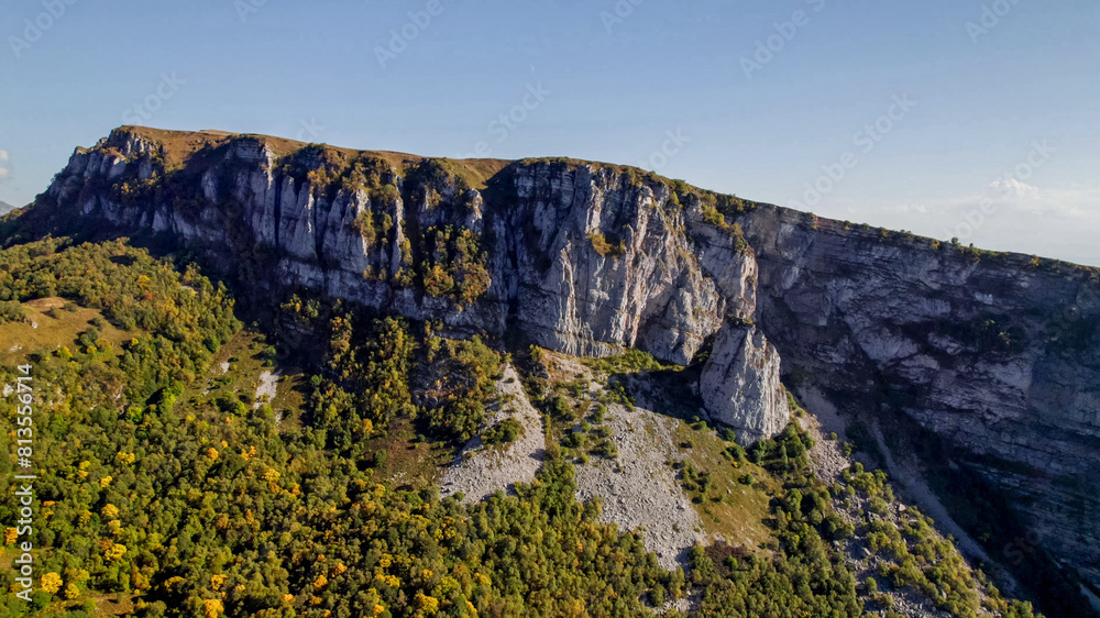 Scenic aerial view of a majestic mountain cliff with autumn foliage, perfect for nature and adventure themes, Earth Day, and environmental conservation content Scenic aerial view of a majestic mountain cliff with autumn foliage, perfect for nature and adventure themes, Earth Day, and environmental conservation content