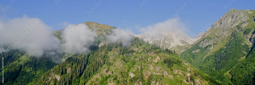 Breathtaking panoramic view of misty green mountains under a clear sky, perfect for Earth Day promotions or nature-inspired travel advertisements