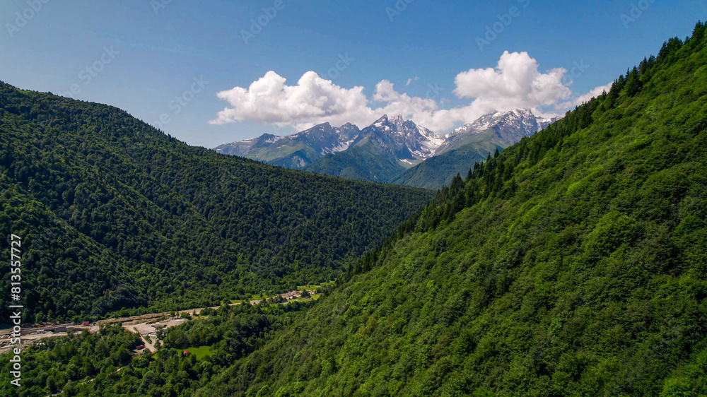 Lush green mountain slopes lead to snow-capped peaks under a clear sky, ideal for Earth Day and International Mountain Day themes Lush green mountain slopes lead to snow-capped peaks under a clear sky, ideal for Earth Day and International Mountain Day themes