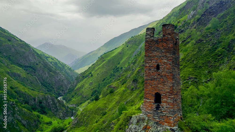 Panoramic view of misty green mountains with an ancient solitary tower, ideal for articles on hiking, nature conservation, and Earth Day backgrounds