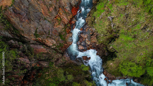 Aerial view of a vibrant forest river canyon with rushing water, ideal for nature and adventure themes, related to Earth Day and environmental conservation