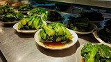 Plates of steamed bok choy with soy sauce in a Chinese restaurant, perfect for Asian cuisine themes and Lunar New Year celebrations