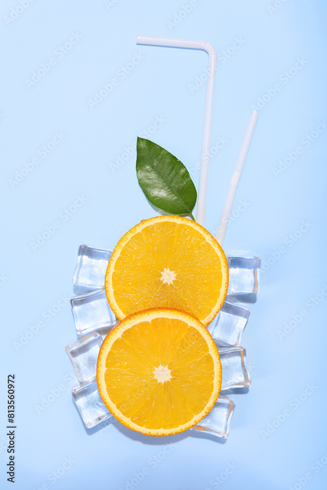 Slices of juicy orange, ice cubes and leaf on light blue background, flat lay Slices of juicy orange, ice cubes and leaf on light blue background, flat lay