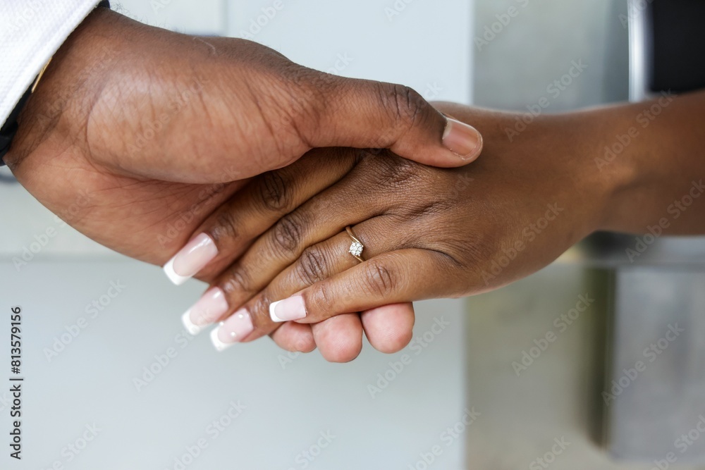Closeup of a groom's hand holding the bride's hand on the wedding day Closeup of a groom's hand holding the bride's hand on the wedding day