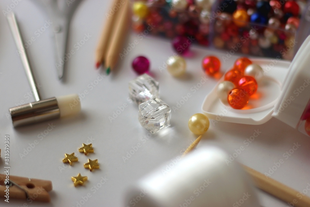Various craft supplies on white background. Supplies for jewelry making, drawing and needlework. Selective focus. Various craft supplies on white background. Supplies for jewelry making, drawing and needlework. Selective focus.