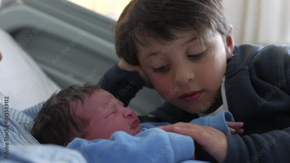 Young boy watching his newborn baby brother at hospital after birth, authentic real life siblings meeting for the first time, day one of infant being welcomed by family at clinic Young boy watching his newborn baby brother at hospital after birth, authentic real life siblings meeting for the first time, day one of infant being welcomed by family at clinic