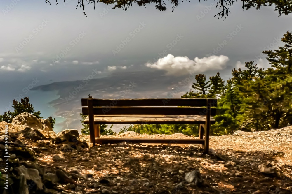 Beautiful shot of a old wooden bench at the top of a mountain looking to the ocean Beautiful shot of a old wooden bench at the top of a mountain looking to the ocean