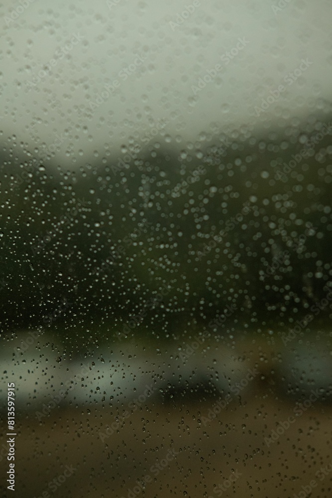 Obraz premium Vertical shot of raindrops on a window